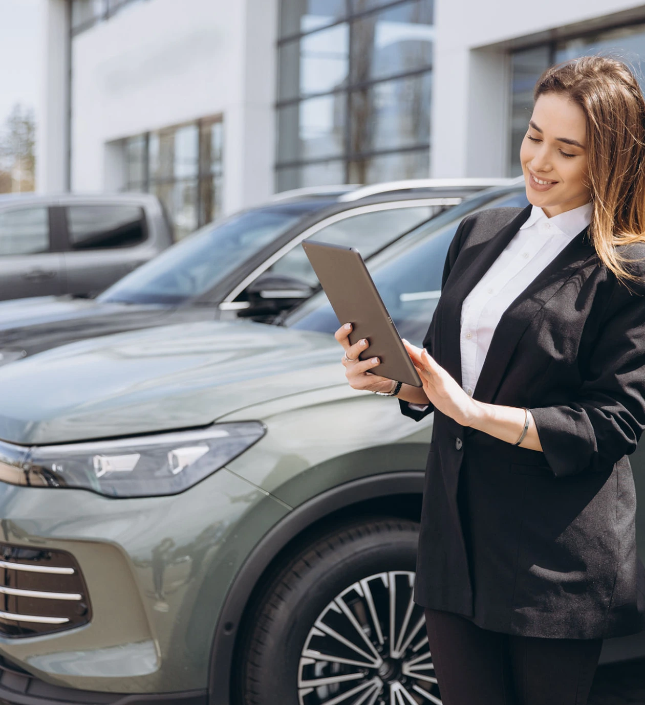 Woman using tablet near parked car